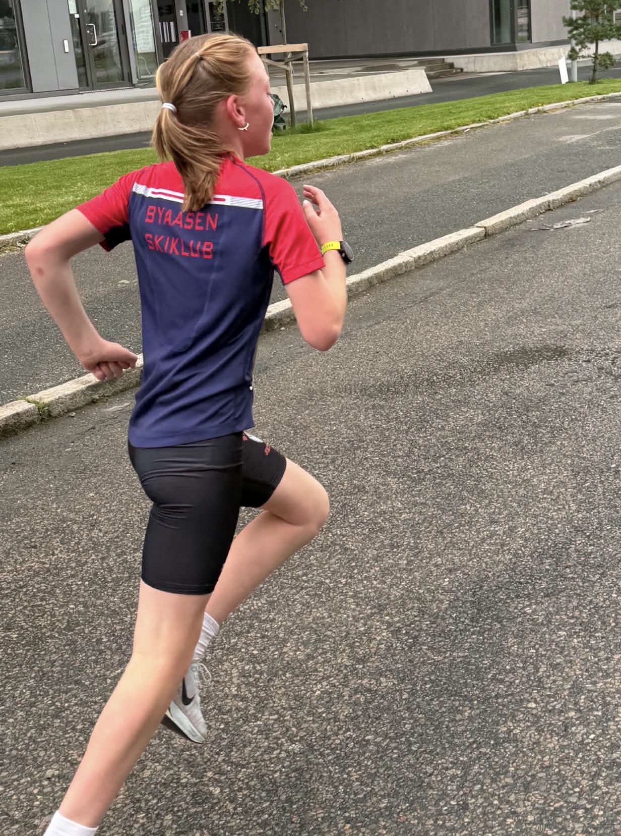 Ung BSK-løper i klubbdress i løp på asfalten under Trondheim Maraton
