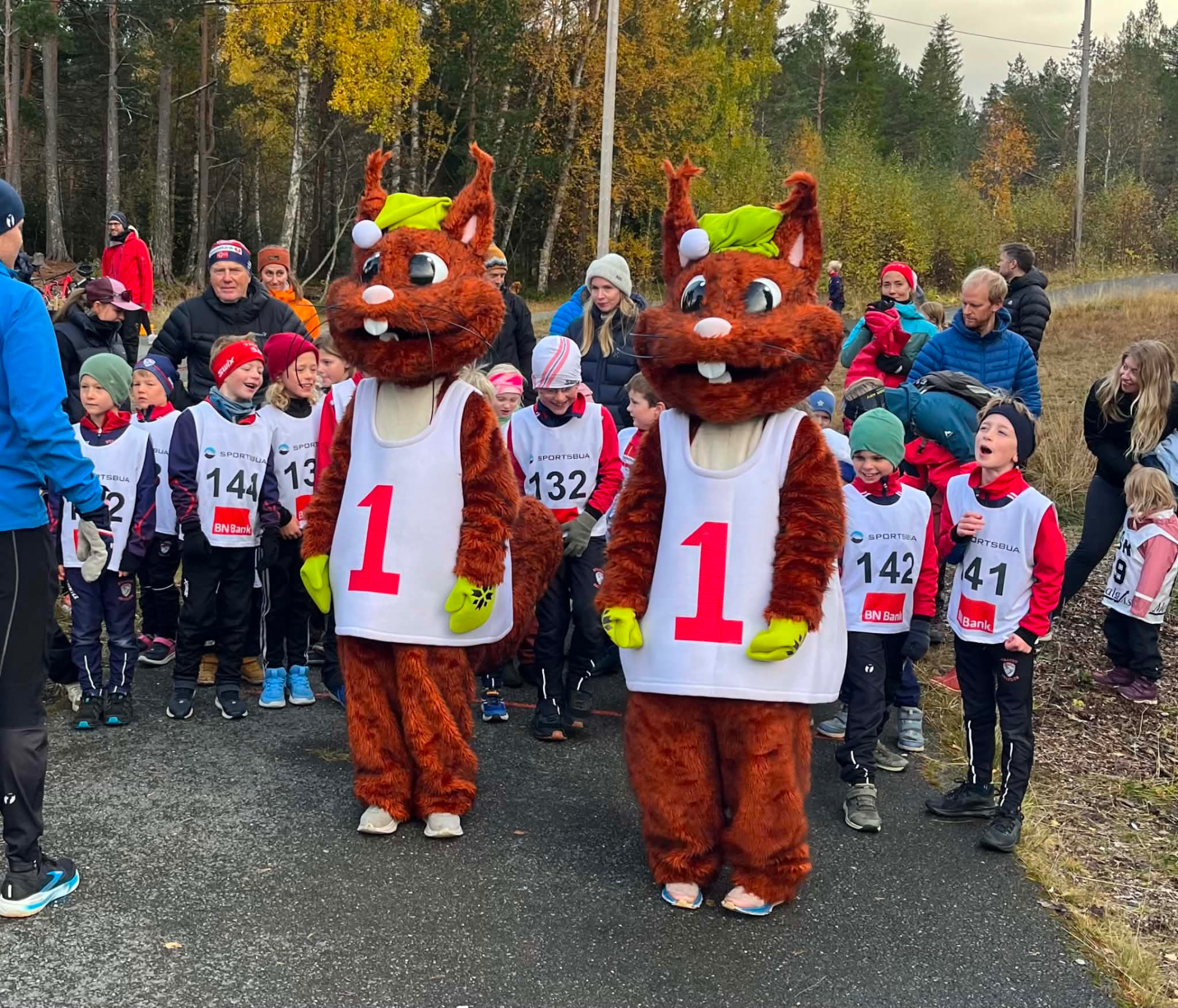 Barn og voksne samlet foran BSK-festivalen med to kostymerte ekorn-maskotter i startområdet