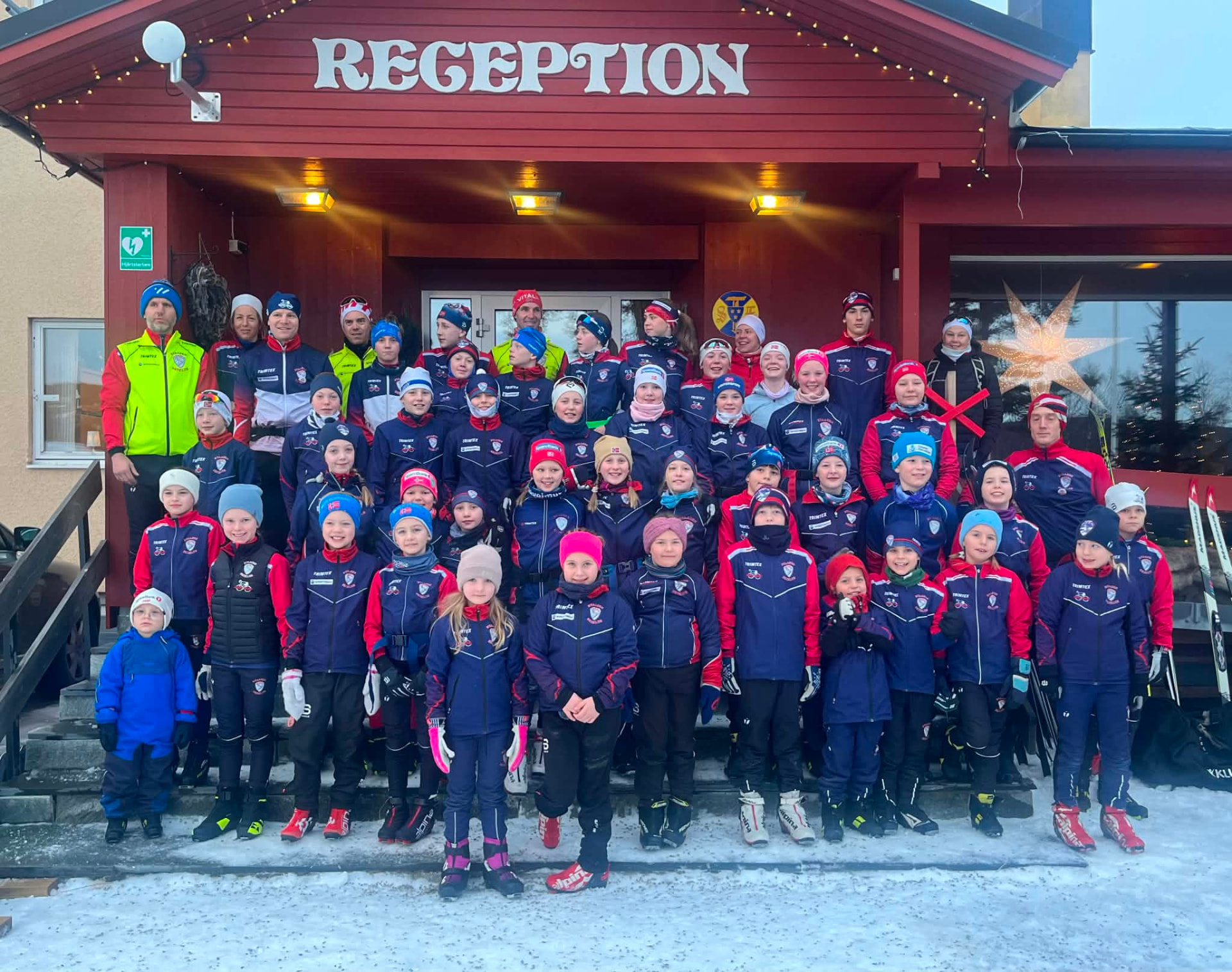 Barn og voksne fra Byaasen Skiklub samlet foran resepsjonen i vinterklær